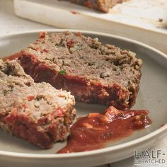 meatloaf on a plate with sauce and bread