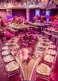 the tables are set up with pink flowers and silverware for an elegant wedding reception