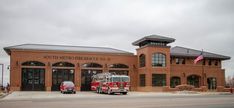 two fire trucks are parked in front of the fire station