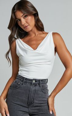 Get ready to turn heads in the Doris Top - Cowl Neck Crop Top in White! This sleek and stylish crop top is perfect for all your party needs. Featuring a trendy cowl neckline and sleeveless design, it's made from soft jersey fabric with a touch of polyester for added comfort. Pair it with high-waisted jeans or a skirt for an effortlessly chic look that will have you feeling confident and empowered all night long. So go ahead, browse our collection of fashion tops and add this must-have piece to y White Cowl Neck Top Outfit, Cowl Neck Top Outfit, Neck Top Outfit, Cowl Neck Crop Top, Chic Outfits Edgy, Stylish Crop Top, Outfits Edgy, Tank Top Outfits, Feeling Confident