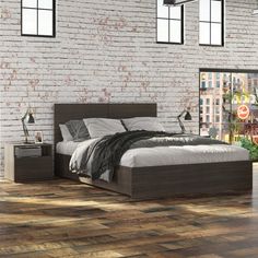 a bedroom with brick walls and hardwood floors