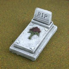 a tombstone with a rose on it sitting on the ground