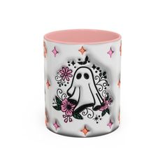 a white and pink coffee mug with a ghost on the front, surrounded by stars