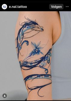 a woman's arm with blue flowers and swirls tattooed on the back of it