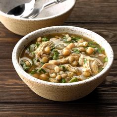 two bowls filled with soup on top of a wooden table