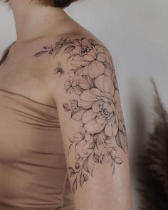 a woman's arm with flowers on it, and the back of her shoulder