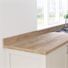 a kitchen counter with a sink and window in the backgroung area above it