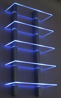 a blue light that is on the side of a wall in front of a white wall