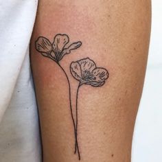 a single flower tattoo on the right arm and leg, with one small flower in the center