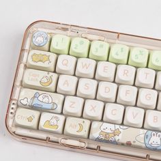 a plastic case holding a white keyboard with cartoon characters on the keys and letters painted on it