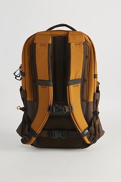 an orange and brown backpack sitting on top of a white table