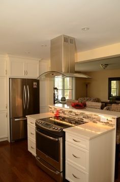 a kitchen with an oven, stove and refrigerator in it's center island area