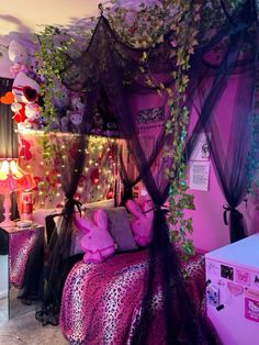 a bedroom decorated in pink and black with lots of decorations on the walls, bedding and canopy