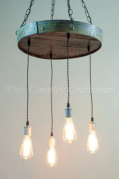 five light bulbs hanging from a chandelier with wood planks and metal chains