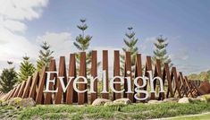 the entrance sign to everlight is surrounded by wooden slats and rocks, with trees in the background