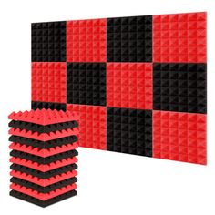 a large red and black wall with some black squares on the bottom, and one smaller square in the middle