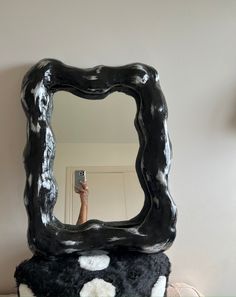 a black and white mirror sitting on top of a table next to a stuffed animal