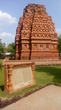 a large brick structure sitting on top of a lush green field