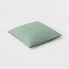 a light green pillow sitting on top of a white surface