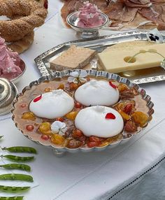 a table topped with lots of different types of food on top of metal trays