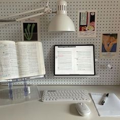 an open book sitting on top of a desk next to a computer keyboard and mouse