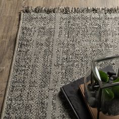 a vase filled with rocks sitting on top of a rug