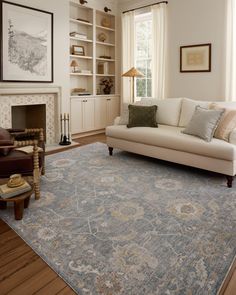 a living room filled with furniture and a large rug on top of a hard wood floor