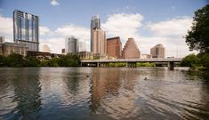 the city skyline is reflected in the water