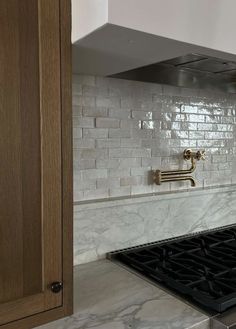 a stove top oven sitting inside of a kitchen next to a wall mounted range hood