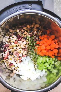 the ingredients for this meal are mixed together in an instant pressure cooker, including carrots, onions, and beans