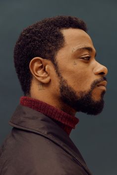 a close up of a person wearing a jacket and neck tie with tattoos on his face