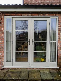 an image of a patio with french doors and brick building in the backround