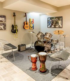 a room with guitars, drums and other musical instruments on the wall in front of it