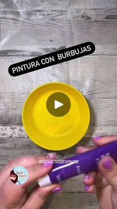 two hands holding a purple toothbrush next to a yellow plate with the words pintura con burbuas on it