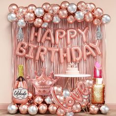 a pink birthday backdrop with balloons and decorations