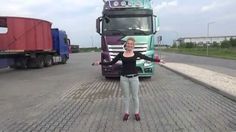 a woman standing in front of a semi truck