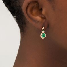 With classic charm, these vintage-inspired drop earrings exude elegance. Crafted in sterling silver with 14K gold plate, each graceful earring showcases a 7.0 x 5.0mm pear-shaped lab-created verdant-green emerald wrapped in a layered frame of lab-created white sapphire-lined ribbons. The floral drop glistens with created sapphires along petal-like marquise shapes and a petite created emerald that connects the dangle to the post. Buffed to a brilliant luster, these earrings secure comfortably wit Lab Created Emerald, Emerald Stone, Sapphire Stone, White Sapphire, Earring Backs, Pear Shaped, Designer Earrings, Sterling Earrings, Sterling Silver Earrings