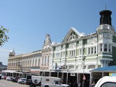 an old building with many cars parked on the street