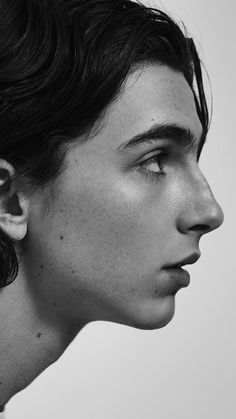 black and white photograph of a young man with ear piercings looking to the side