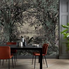 a dining room table with two chairs and a wallpaper mural behind it that has trees in the background