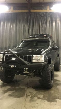 a black truck parked inside of a garage