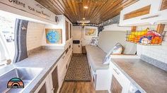 the interior of a camper with wood ceiling and white walls, wooden flooring