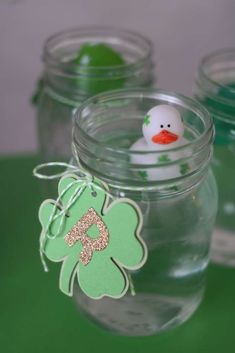 a glass jar filled with water and a rubber duck sitting on top of the lid