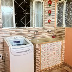 a washer sitting next to a window in a room with tiled walls and floor