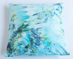 a blue and green pillow sitting on top of a white table