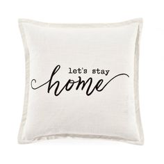 a white pillow with the words let's stay home printed in black on it