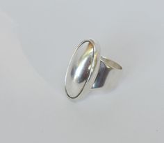 "This unique oval shaped vintage Sterling Silver Ring is large measuring 1 1/4 inches by 3/4 inches. It is artisan made as revealed in its being stamped as \"925\", \"CTI\" and \"Mexico\". It is in very good vintage condition. It is size 6 3/4 but can be readily adjusted without compromising the beauty of its very modernist design. All of our jewelry pieces are sent with \"tracking\" in an attractive gift box and safely mailed in a bubble wrap lined envelope. We ship to most International Locati Silver Oval Cabochon Signet Ring, Vintage Oval Dome Ring With Polished Finish, Classic Oval Dome Ring Stamped 925, Classic Silver Oval Dome Ring, Adjustable Oval Signet Ring With Polished Finish, Oval Adjustable Signet Ring With Polished Finish, Oval Silver Signet Ring With Cabochon, Vintage Dome Ring With Polished Oval Cabochon, Vintage Dome Ring With Oval Cabochon Polished Finish