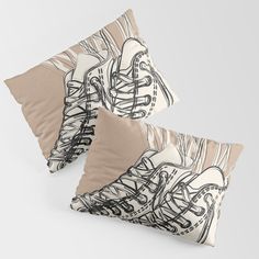 two pillows with black and white drawings on them, one has a beige pillow case