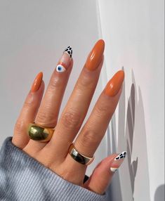 a woman's hand with two rings on it, and an orange manicure