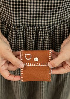 a person holding a piece of leather with hearts on it